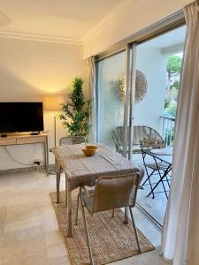 d'un salon avec une table et un balcon. dans l'établissement Studio à Golfe Juan, terrace, piscine, près plages, à Vallauris