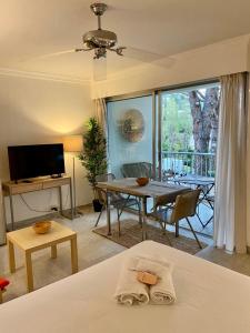 - un salon avec un lit et une salle à manger avec une table dans l'établissement Studio à Golfe Juan, terrace, piscine, près plages, à Vallauris