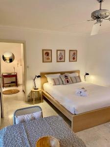 - une chambre avec un grand lit blanc et un canapé dans l'établissement Studio à Golfe Juan, terrace, piscine, près plages, à Vallauris
