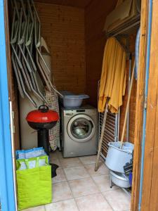 a laundry room with a washing machine and a washer at LES CHALETS DE LA VIGNE GRANDE in Saint-Floret