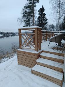 een terras met een met sneeuw bedekte trap en een tafel bij Villa Riverside in Rovaniemi