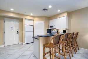 a kitchen with a counter with chairs in it at Harbour House at the Inn 204 in Fort Myers Beach