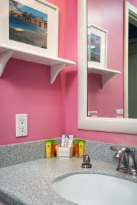 a bathroom with a sink and a pink wall at Harbour House at the Inn 204 in Fort Myers Beach