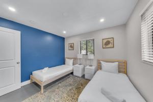 - une chambre avec 2 lits et un mur bleu dans l'établissement Coconut Bungalow - Modern 3 1 in Grove Bay, à Miami