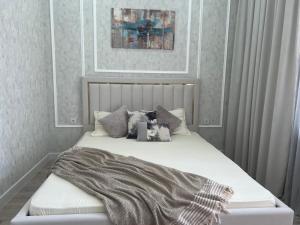 a bed with a blanket on it in a bedroom at Уютная квартира вблизи Байтерека in Astana