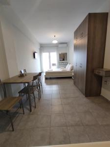 a living room with a table and chairs and a couch at Sea View Apartments Nikos in Nea Peramos
