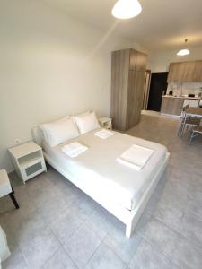 a bedroom with a large white bed in a room at Sea View Apartments Nikos in Nea Peramos