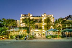 a large building with umbrellas in front of it at The Nam An Villa Hoi An in Hoi An