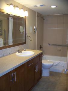 ein Badezimmer mit einem Waschbecken, einem WC und einem Spiegel in der Unterkunft Sea Village in Kailua-Kona