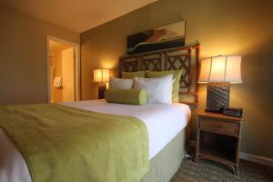 a bedroom with a large bed and two lamps on a table at Sea Village in Kailua-Kona