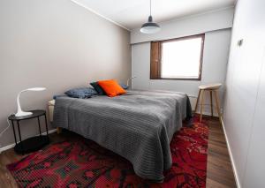 Dormitorio con cama con almohada naranja en Koivutie Apartment en Ranua