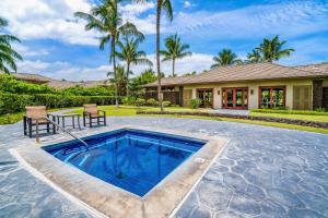 ワイコロアにあるKulalani at Mauna Lani 2301の家の前にテーブルと椅子のあるスイミングプール