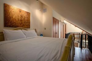 Un dormitorio con una gran cama blanca y una escalera. en The Ikon Lofted Studio with King Bed and Patio, en Whistler