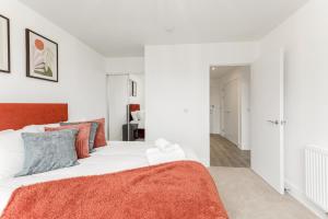 a white bedroom with an orange blanket on a bed at CannyCity in London