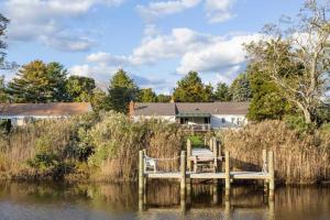 un muelle sobre un cuerpo de agua con una casa en Bright Oasis in Beautiful North Fork Wine Country, en Southold