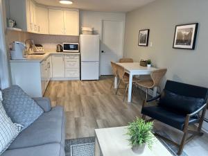 a living room with a couch and a table and a kitchen at Mountain View Bed & Breakfast in Banff