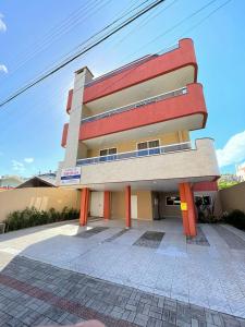 un bâtiment avec des piliers orange devant lui dans l'établissement Residencial 364 - Localização privilegiada à 5min da praia, à Bombinhas