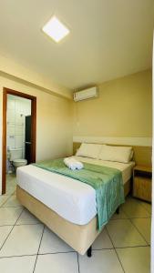 um quarto com uma cama num quarto com uma casa de banho em Residencial 364 - Localização privilegiada à 5min da praia em Bombinhas
