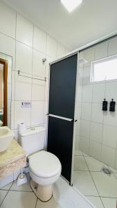 uma casa de banho com um WC, um chuveiro e um lavatório. em Residencial 364 - Localização privilegiada à 5min da praia em Bombinhas
