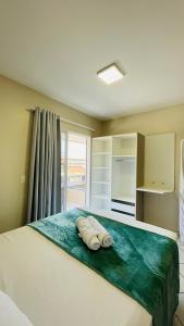 1 dormitorio con 1 cama con toallas en Residencial 364 - Localização privilegiada à 5min da praia, en Bombinhas