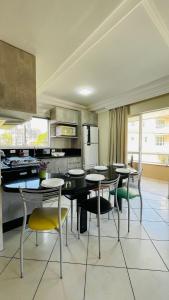 a kitchen with a table and chairs in a room at Residencial 364 - Localização privilegiada à 5min da praia in Bombinhas