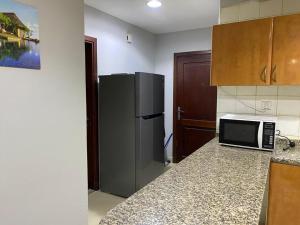a kitchen with a refrigerator and a counter top at Lovely Partition Room in Barsha 1 Near Metro in Dubai