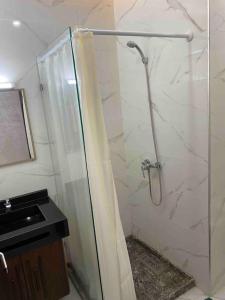 a bathroom with a shower with a glass door at Appartement sala al jadida in Oulad Yakoub
