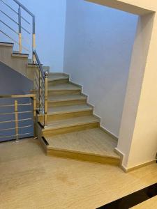 a staircase in a building with wooden floors andsteel railing at Appartement sala al jadida in Oulad Yakoub
