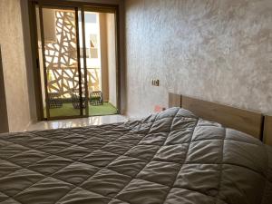 a large bed in a room with a window at Appartement sala al jadida in Oulad Yakoub
