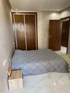 a bedroom with a bed and a wooden door at Appartement sala al jadida in Oulad Yakoub