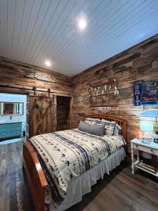ein Schlafzimmer mit einem Bett und einer Holzwand in der Unterkunft New Waterfront Cabin, 62 Acre, King Beds, Fire pit, Hiking in Columbia