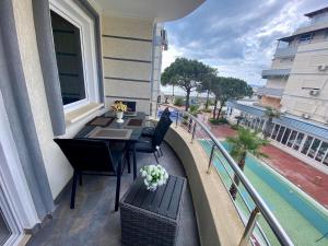 a balcony with a table and chairs and a pool at Sunset Appartment in Golem +2 photos