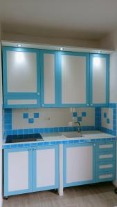 una cocina con armarios azules y fregadero en Domo Mea, en Miniera dellʼArgentiera