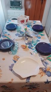una mesa con placas azules y utensilios en ella en Domo Mea, en Miniera dellʼArgentiera