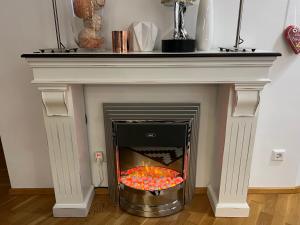 a fireplace with a white mantle with balls in it at Luxury Apartment Villach City in Villach