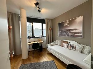 a living room with a white couch and a desk at Luxury Apartment Villach City in Villach