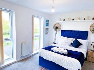 a bedroom with a blue and white bed and windows at Family, Group & Contractor Stay - Sleeps Upto 9 Guests with Free Parking in Birmingham