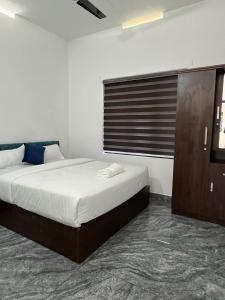 1 dormitorio con 1 cama grande y ventana en Hayat Residency - The Quarry Lake en Kalpetta