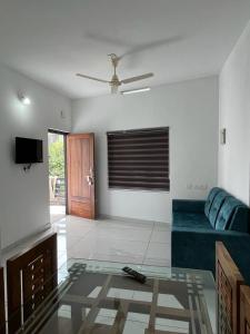 a living room with a couch and a glass table at Hayat Residency - The Quarry Lake in Kalpetta