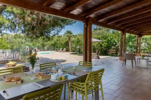 un patio con mesa, sillas y piscina en Villa Sorbole, en Ostuni