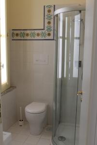 a bathroom with a toilet and a glass shower at Le Petit Bouganville in Salerno