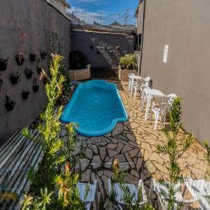 uma piscina no meio de um pátio em Carpi Apartamentos Ubatuba em Ubatuba