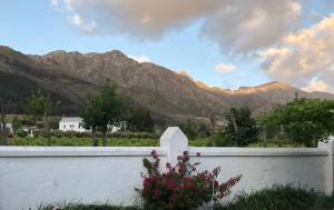 a white fence with mountains in the background at Gooding's Olive Villa in Franschhoek