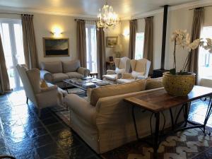 a living room with a couch and chairs and a table at Gooding's Olive Villa in Franschhoek