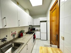 a kitchen with white cabinets and a sink and a counter at Habitaciones acogedoras in Barcelona