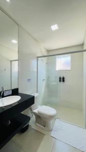uma casa de banho com um WC e uma cabina de duche em vidro. em Residencial 287 - Localização privilegiada à 5min da praia em Bombinhas