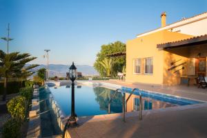 a swimming pool next to a house and a building at Villa Mouttali in Paphos