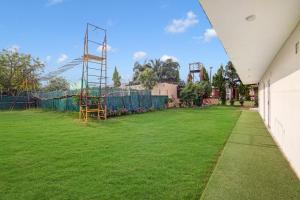 a large grassy yard with a playground at Palette - JPS Residency in Gurgaon