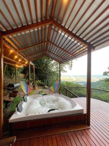 bañera de hidromasaje en una terraza con pérgola en Senderos Glamping, en Villavicencio