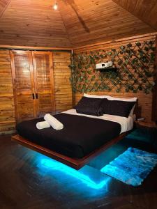 ein Schlafzimmer mit einem Bett in einem Holzzimmer in der Unterkunft Senderos Glamping in Villavicencio